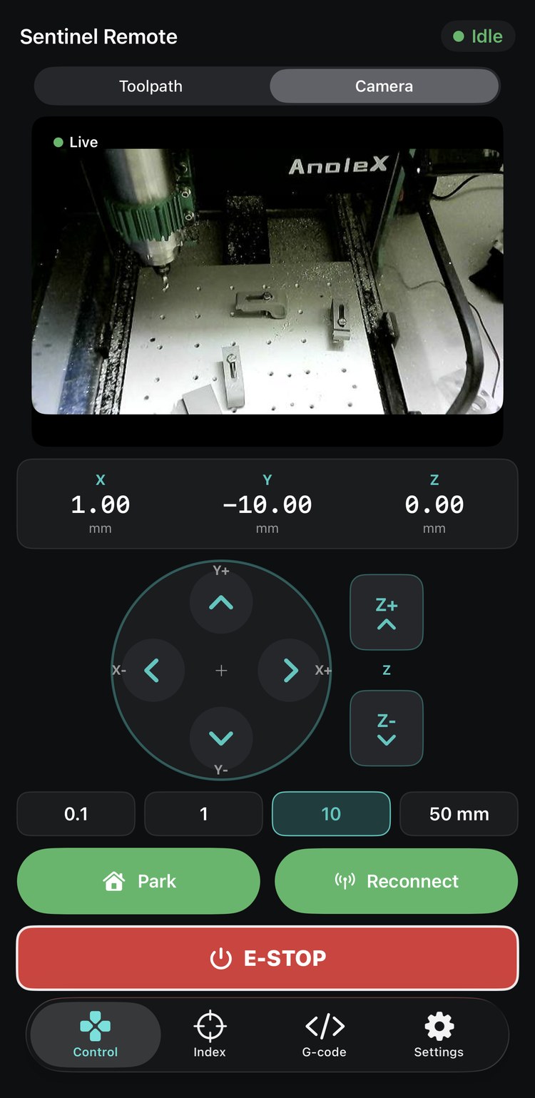 Sentinel Remote on iPhone showing the live camera tab: a video feed of the CNC spindle over a fixtured aluminium plate, above the same jog and E-STOP controls